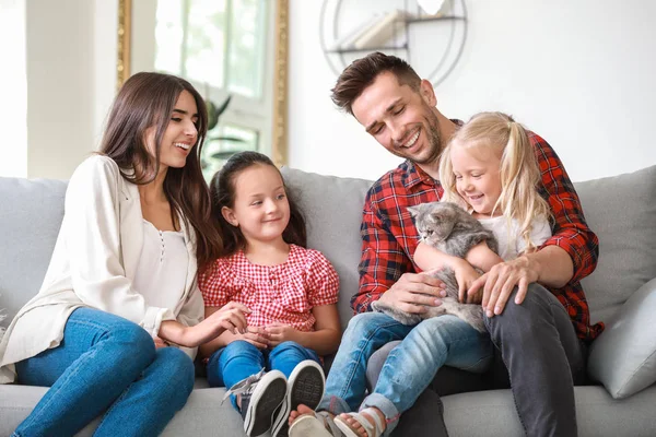 Gelukkige familie met schattige kat die thuis rust — Stockfoto