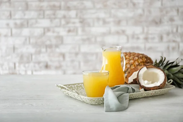 Composition with fresh pineapple juice and coconut on table — Stock Photo, Image