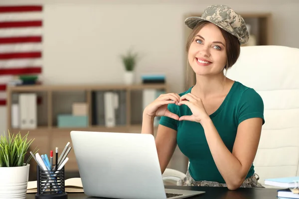 Female soldier using laptop in headquarters building for communication with her family — Stock Photo, Image