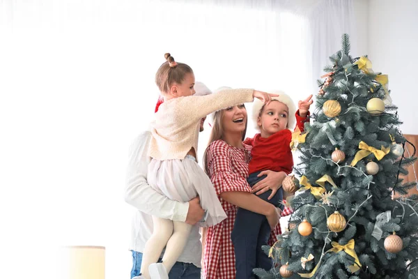 Familia feliz cerca del árbol de Navidad decorado en casa — Foto de Stock