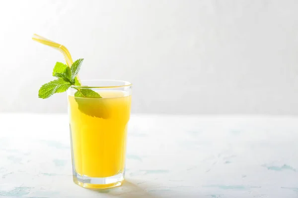 Vaso de jugo de piña fresco sobre una mesa ligera — Foto de Stock