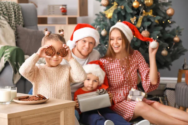 Little girl with tasty cookies and her family at home on Christmas eve — Stock Photo, Image