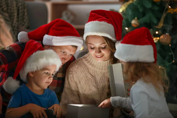 Lycklig familj öppnar julklappar på kvällen — Stockfoto