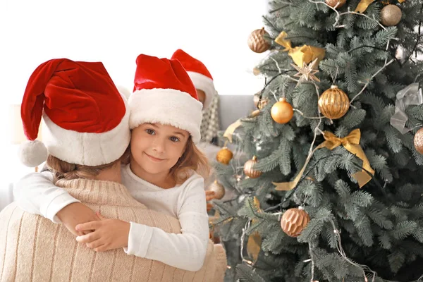 Glückliche Mutter mit kleiner Tochter zu Hause am Weihnachtsbaum — Stockfoto