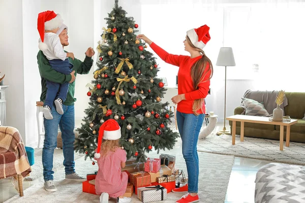 Happy family decorating Christmas tree at home — Stock Photo, Image