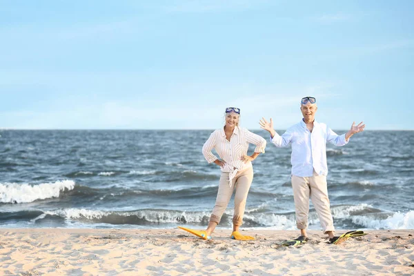 Glückliches älteres Paar mit Schnorchelmasken und Paddeln, das Spaß im Seebad hat — Stockfoto
