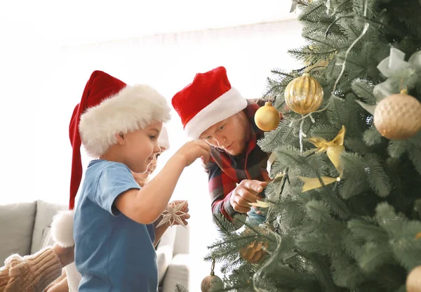 Happy family decorating Christmas tree at home — Stock Photo, Image