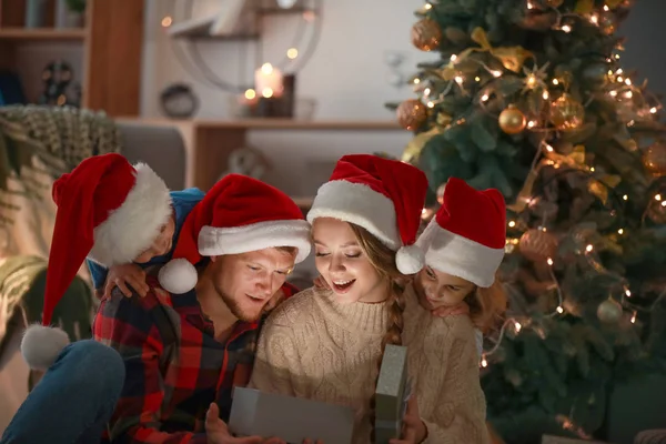 Lycklig familj öppnar julklappar på kvällen — Stockfoto