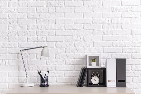 Stylish workplace near white wall in room — Stock Photo, Image