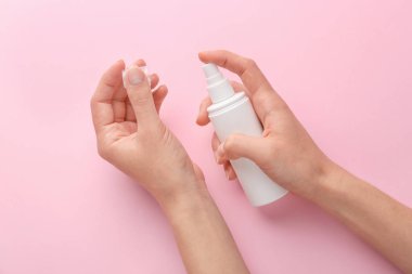 Renkli arka planda kozmetik ürünü olan kadın elleri