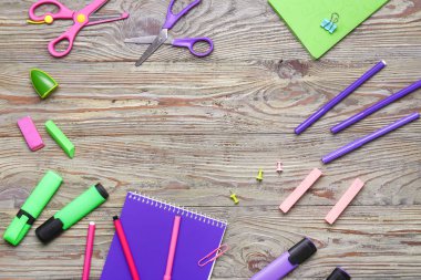 Ahşap arka plan üzerinde okul malzemelerinden yapılmış çerçeve