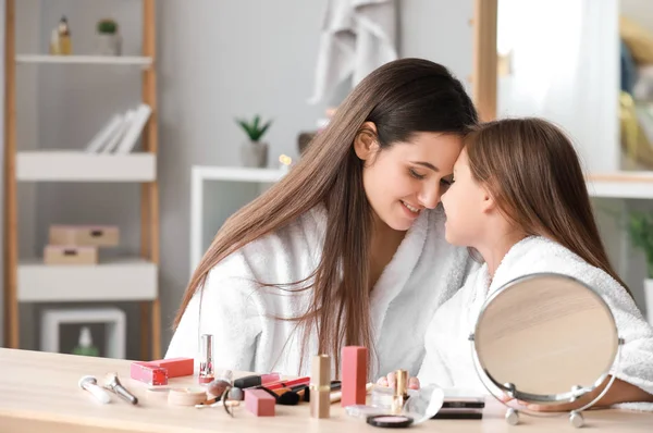 Matka i jej mała córka w szlafroków stosujących makijaż w domu — Zdjęcie stockowe