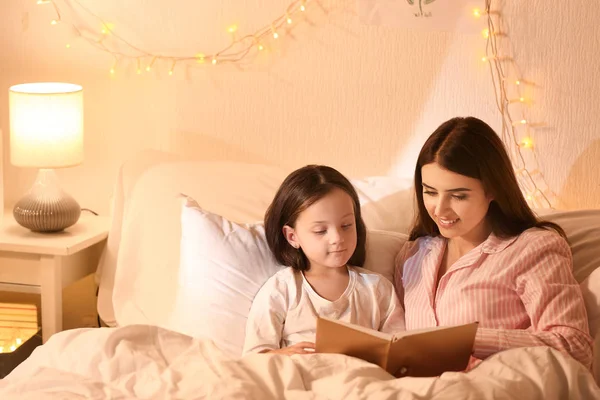 Mother and her little daughter reading bedtime story at home — Stock Photo, Image