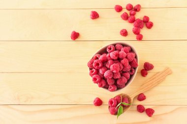 Ahşap masa üzerinde taze ahududu ile Kase ve kaşık