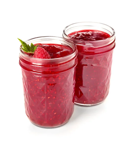 Jars of tasty raspberry jam on white background — Stock Photo, Image