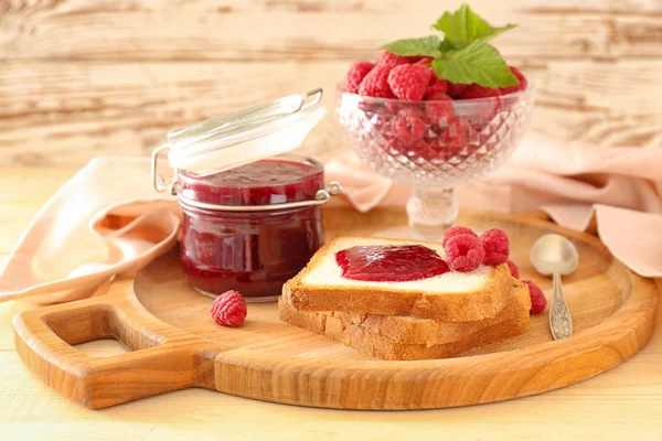 Confiture de framboises savoureuse avec pain frais sur planche de bois — Photo