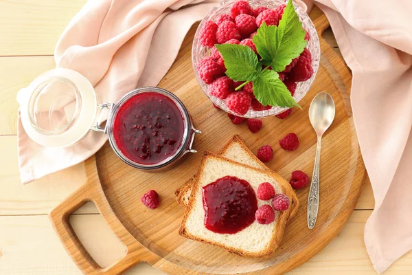 Confiture de framboises savoureuse avec pain frais sur planche de bois — Photo