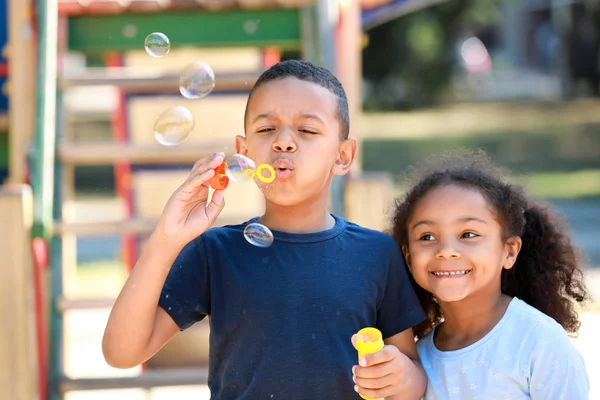 Cute African-American children blowing soap bubbles outdoors — Stock Photo, Image