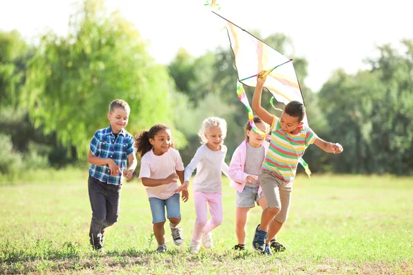 Grupa szczęśliwych dzieci z latawcem w parku — Zdjęcie stockowe