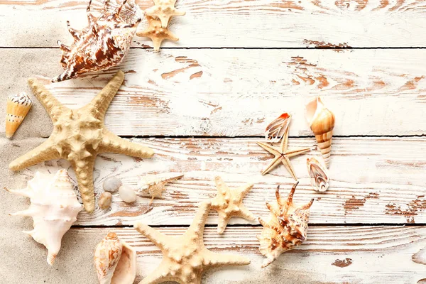 Beautiful sea shells and starfish on wooden background — Stock Photo, Image