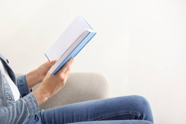 Kadın evde kitap okuyor.