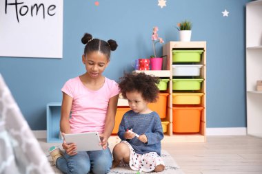 Tablet bilgisayar evde çizgi film izlerken sevimli Afrikalı-Amerikalı kız