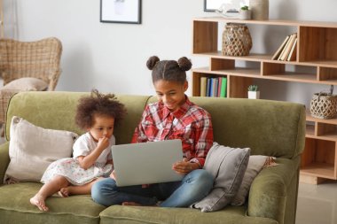 Evde çizgi film izlerken dizüstü bilgisayar ile Sevimli Afrikalı-Amerikalı kız kardeşler