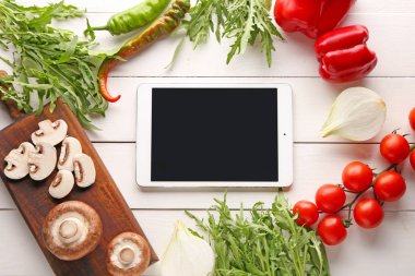 Beyaz ahşap arka plan üzerinde taze ürünler ile modern tablet bilgisayar