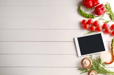 Beyaz ahşap arka plan üzerinde taze ürünler ile modern tablet bilgisayar