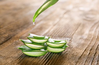 Ahşap arka planda taze aloe dilimleri