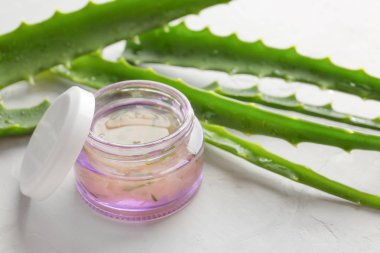 Hafif arka planda kozmetik ürün ve aloe ile Kavanoz