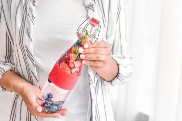 Woman with bottle of infused water at home — Stock Photo, Image