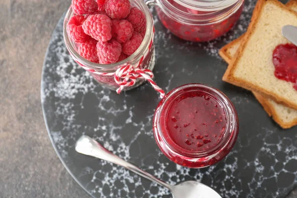 Tasty raspberry jam with bread on board — Stock Photo, Image