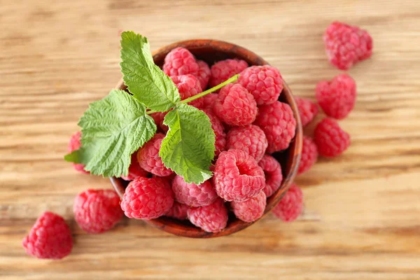 Bowl with sweet ripe raspberries on wooden table — Stock Photo, Image