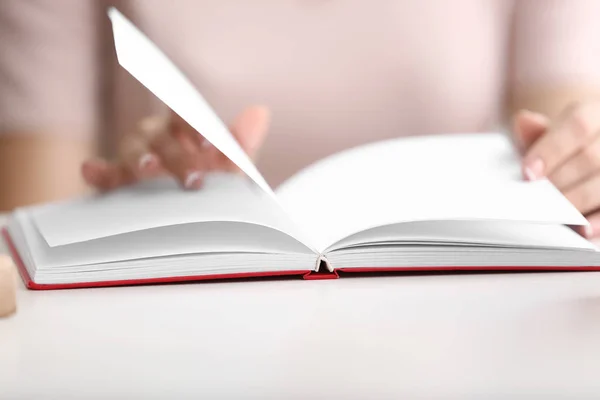 Woman reading book at table, closeup — Stock Photo, Image