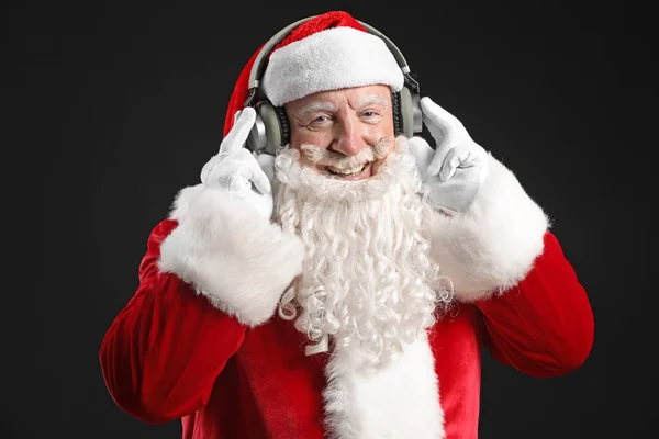 Retrato de Santa Claus escuchando música sobre fondo oscuro —  Fotos de Stock