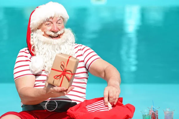 Papai Noel com presentes perto da piscina no resort — Fotografia de Stock