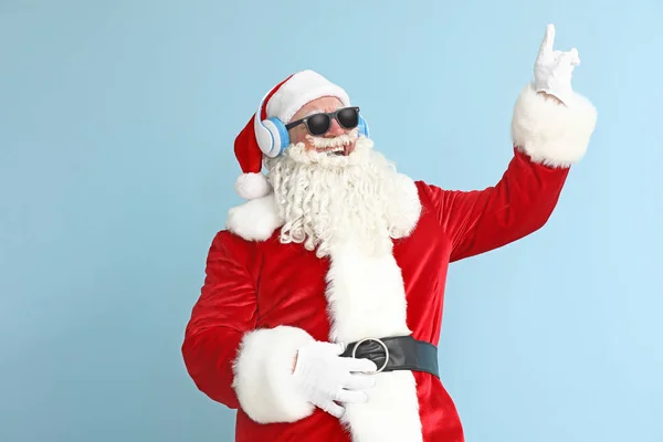 Retrato de Papai Noel legal ouvindo música no fundo de cor — Fotografia de Stock