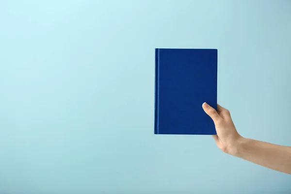 Female hand with book on color background — Stock Photo, Image