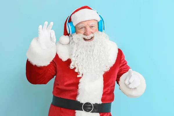 Retrato de Santa Claus escuchando música sobre fondo de color —  Fotos de Stock