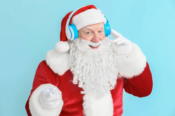 Retrato de Santa Claus escuchando música sobre fondo de color —  Fotos de Stock