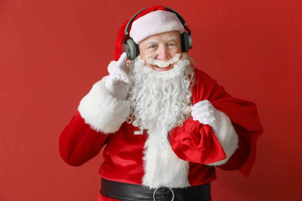 Retrato de Santa Claus escuchando música sobre fondo de color —  Fotos de Stock