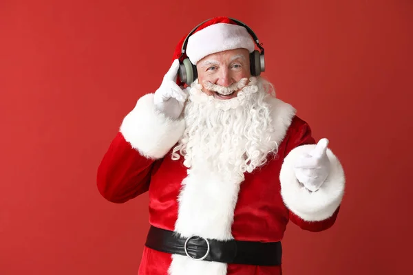 Retrato de Santa Claus escuchando música sobre fondo de color —  Fotos de Stock