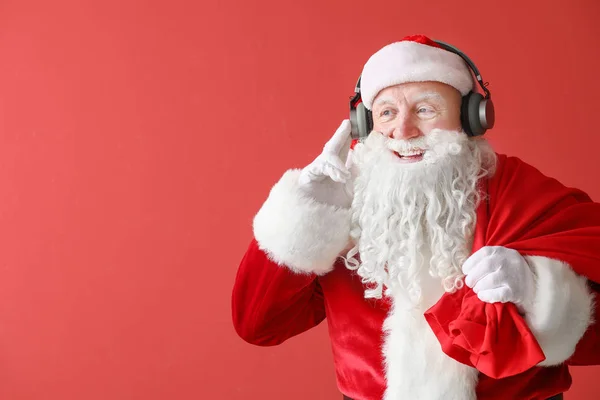 Retrato de Santa Claus escuchando música sobre fondo de color —  Fotos de Stock