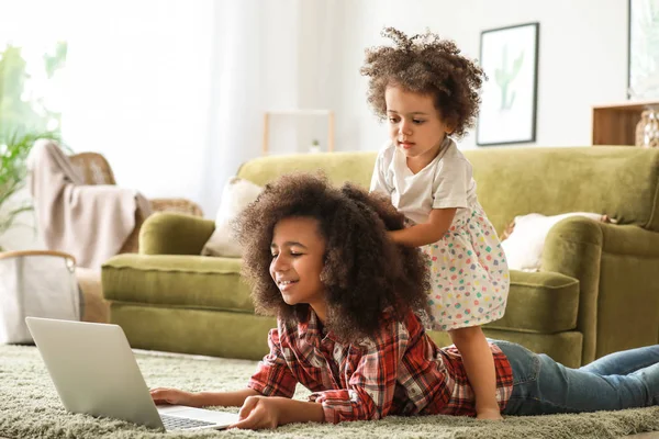 Lindas hermanas afroamericanas con portátil viendo dibujos animados en casa — Foto de Stock
