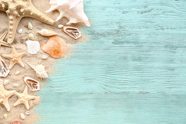 Beautiful sea shells, starfish and sand on wooden background — Stock Photo, Image