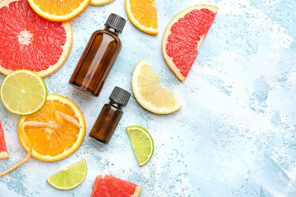 Composition with citrus essential oil on color background