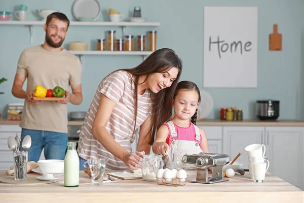 Jovem família cozinhar juntos na cozinha — Fotografia de Stock