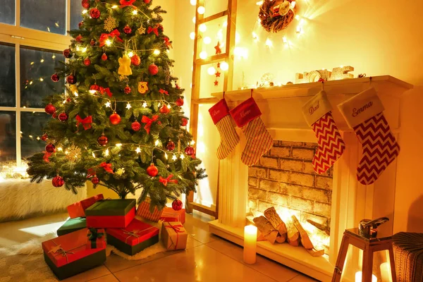 Árbol de Navidad bellamente decorado con cajas de regalo en la habitación —  Fotos de Stock