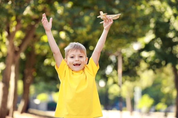 Söt liten pojke leker med trä flygplan i parken — Stockfoto